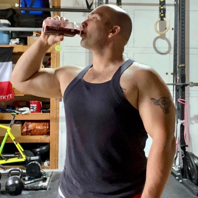 Athlete drinking a beet juice after a garage gym workout